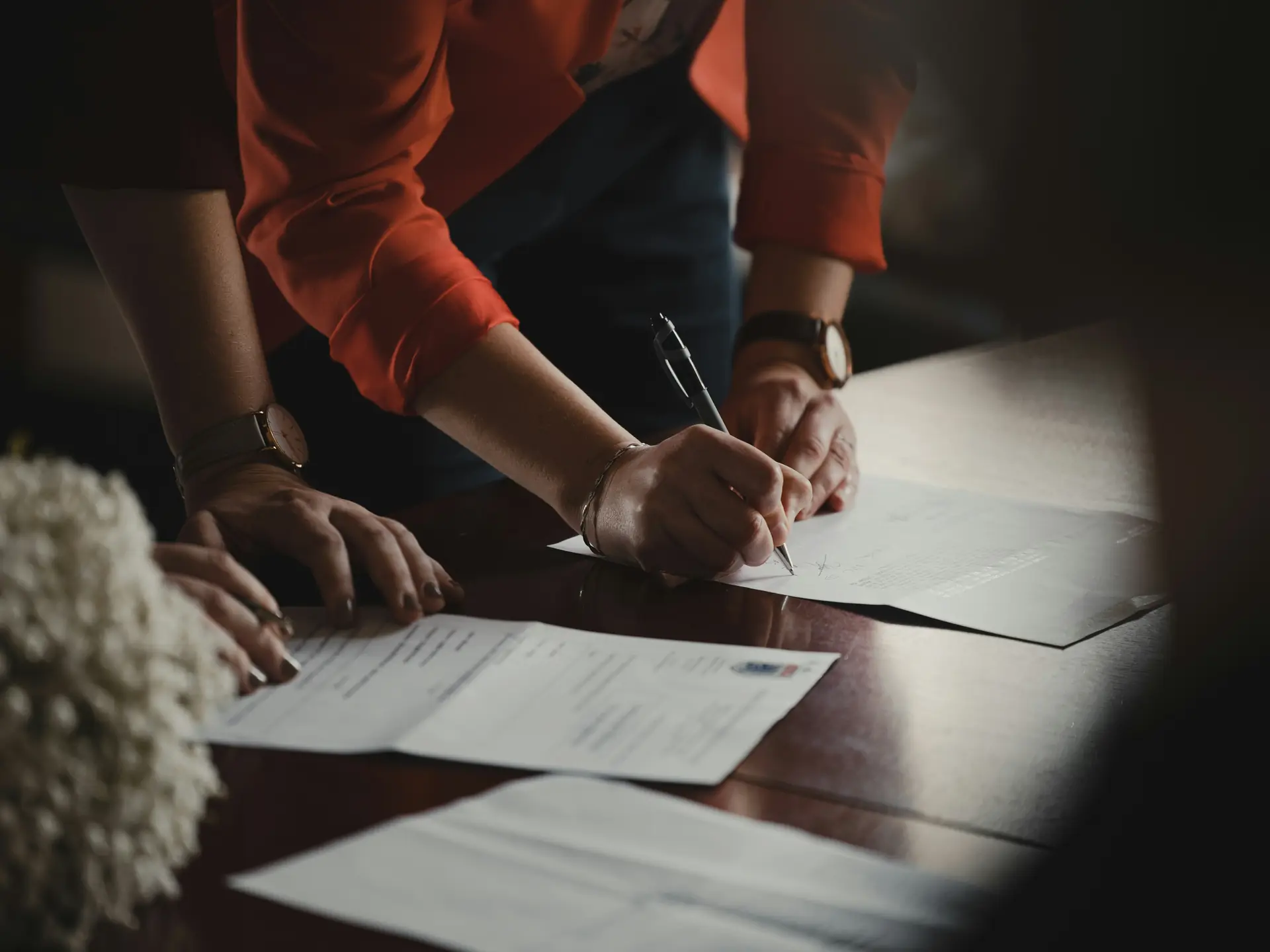 Two people leaning over a table signing founding documents
