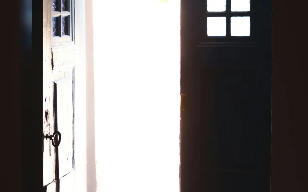 An old double door standing open to bright morning light